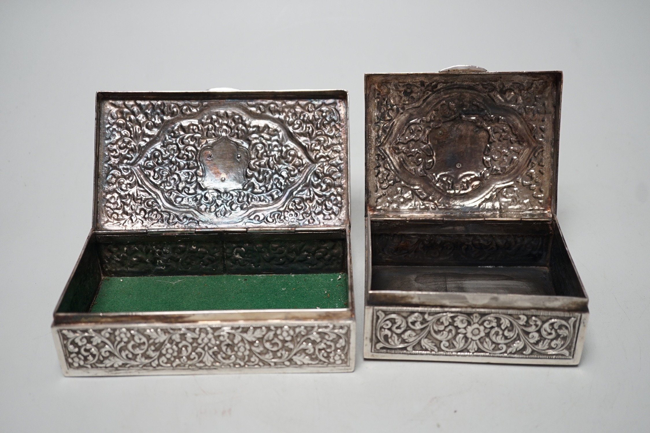 Two early 20th century Indian embossed white metal rectangular boxes, both applied with the enamelled rest of the Bhuj Kutch Gujarat, largest 14.2cm
